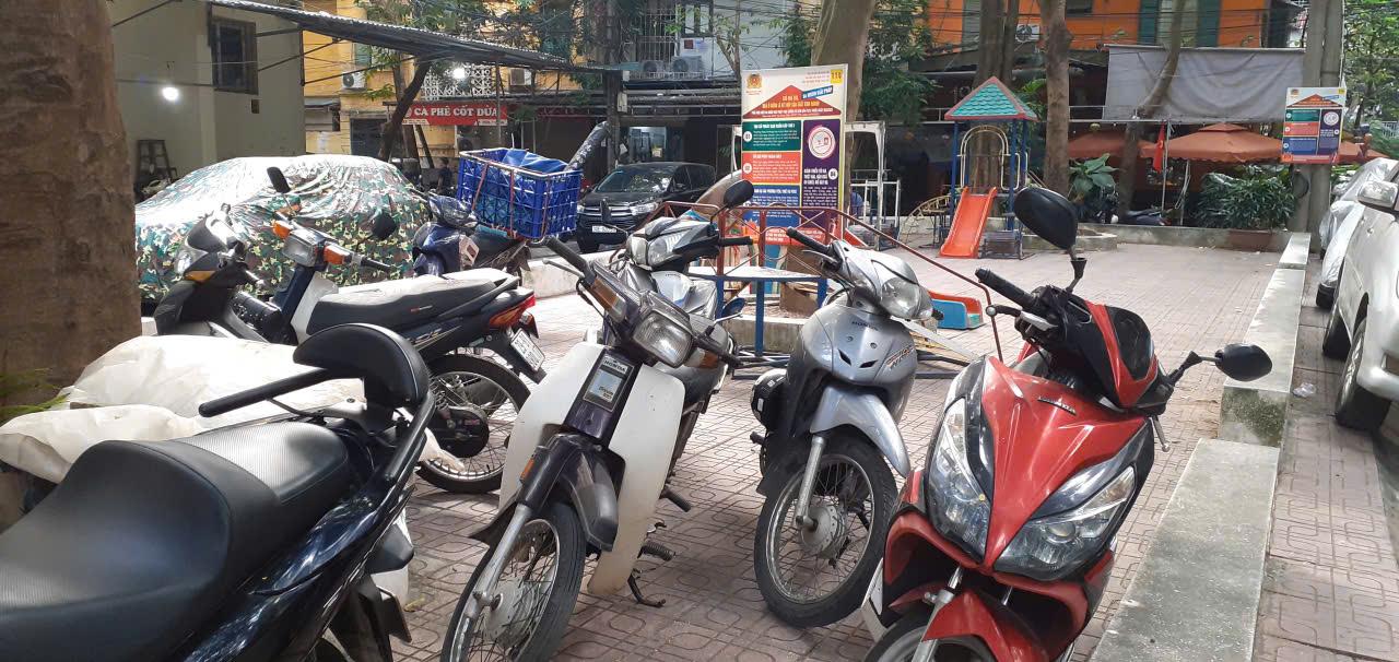 <em>Nội quy sân chơi khu tập thể 7,2ha ghi rõ chỉ cho trẻ em dưới 15 tuổi vào sân chơi, nhưng hiện nửa sân đang dành cho người lớn để xe. Ảnh: Thùy Linh</em>