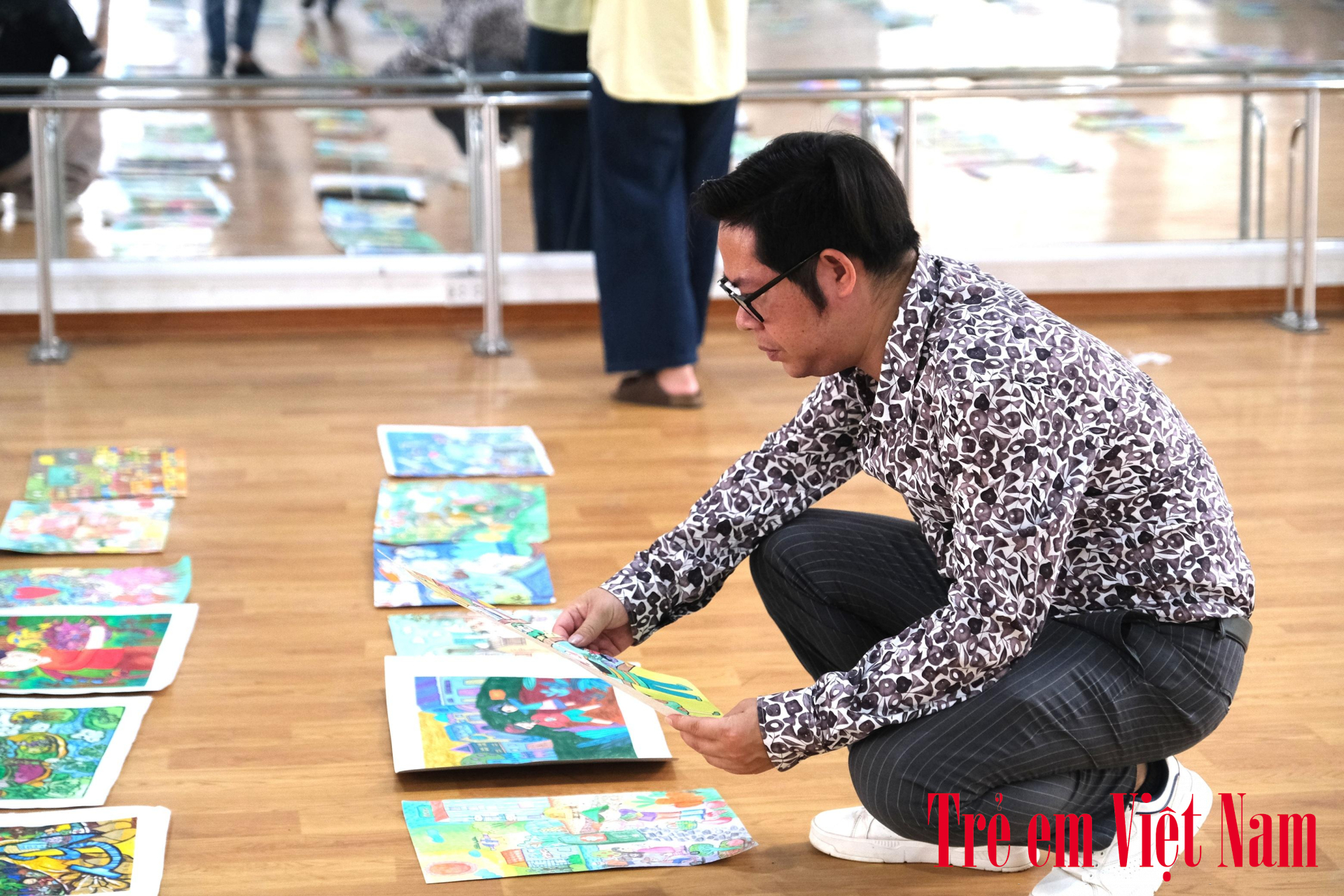 Họa sĩ Nguyễn Hòa cân nhắc từng nét vẽ, đọc kỹ từng thông điệp của các thí sinh. Ảnh: LC họa sĩ nguyễn hòa