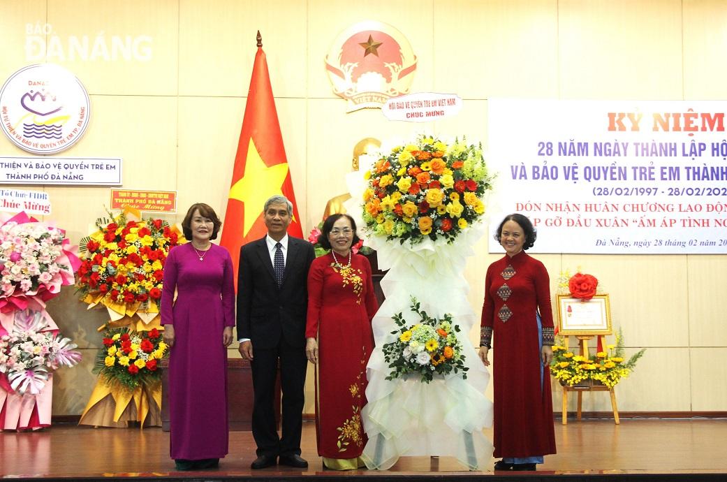 Phó Chủ tịch Hội Bảo vệ quyền trẻ em Việt Nam Cao Thị Thanh Thủy tặng hoa chúc mừng kỷ niệm 28 năm ngày thành lập Hội Từ thiện và Bảo vệ quyền trẻ em thành phố (28-2-1997 - 28-2-2025). Ảnh: L.P