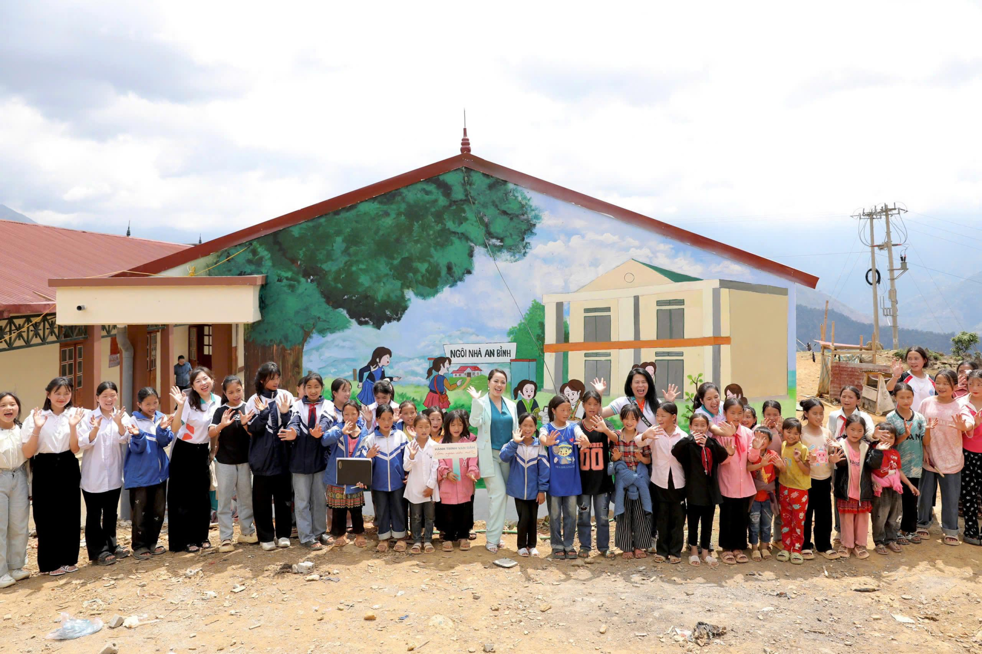 Các em nhỏ hân hoan trước bức tường Ngôi nhà An Bình sinh động, nhiều màu sắc. A2