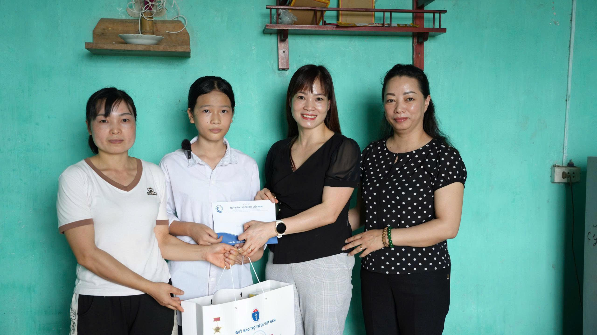 Bà Nguyễn Thị Hiền - Phó Giám đốc Quỹ BTTEVN thăm hỏi, tặng quà cháu Đinh Thị Châm - thôn Đông Nam, xã Đông Ngũ, huyện Tiên Yên, tỉnh Quảng Ninh - trẻ em hưởng lợi từ dự án A1