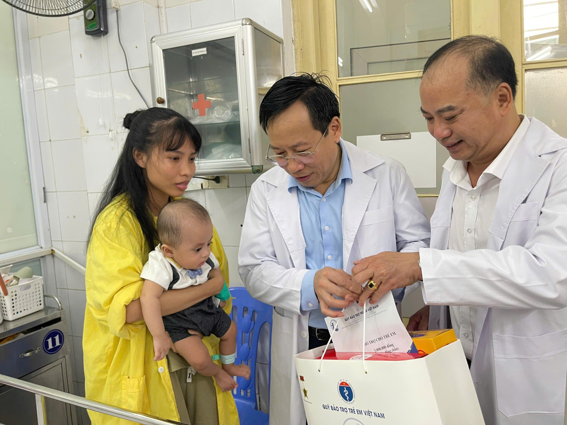 Ông Lê Đức Luận - Thứ trưởng Bộ Y tế và Ông Đinh Tiến Hải - Giám đốc Quỹ Bảo trợ trẻ em Việt Nam trao quà cho trẻ em tại Khoa Nhi, Bệnh viện Phổi Trung ương. A4