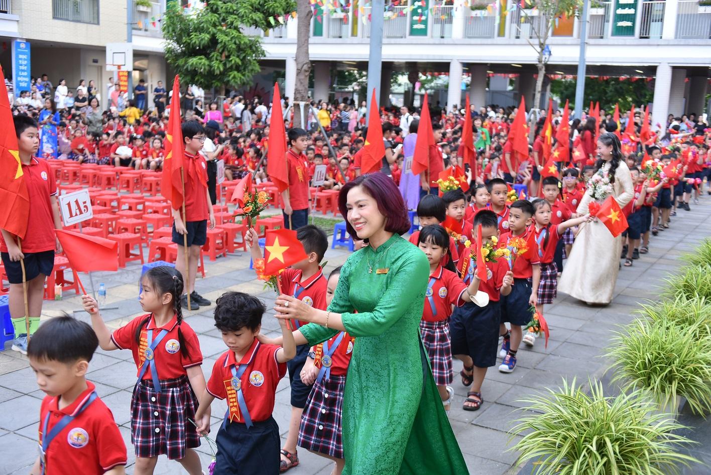 Nhà giáo Nguyễn Thị Vân Anh - Bí thư Chi bộ, Hiệu trưởng Trường Tiểu học Kim Đồng (Giảng Võ, Hà Nội) chào đón học sinh vào lớp 1. NIK_5296