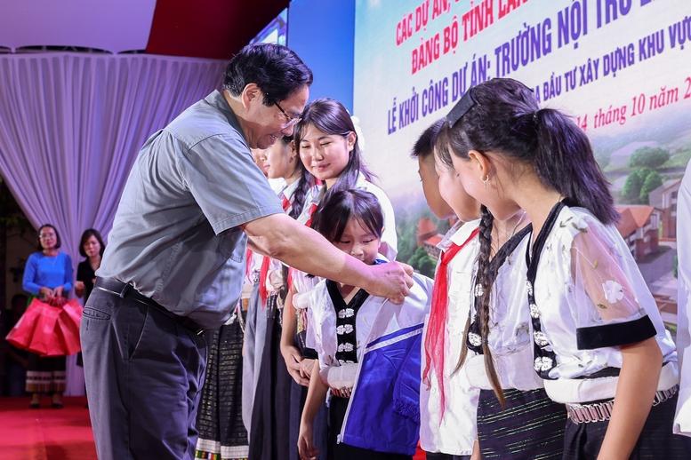 Thủ tướng Phạm Minh Chính tặng áo ấm cho các em học sinh - Ảnh: VGP/Nhật Bắc thủ tướng 4